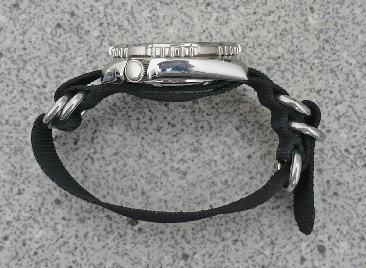 Side view of a watch on a black nylon NATO strap